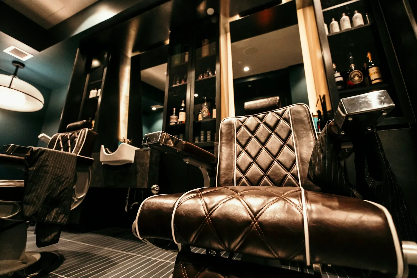 Cadeiras e espelhos de uma barbearia contemporânea, em fotografia de banco.
