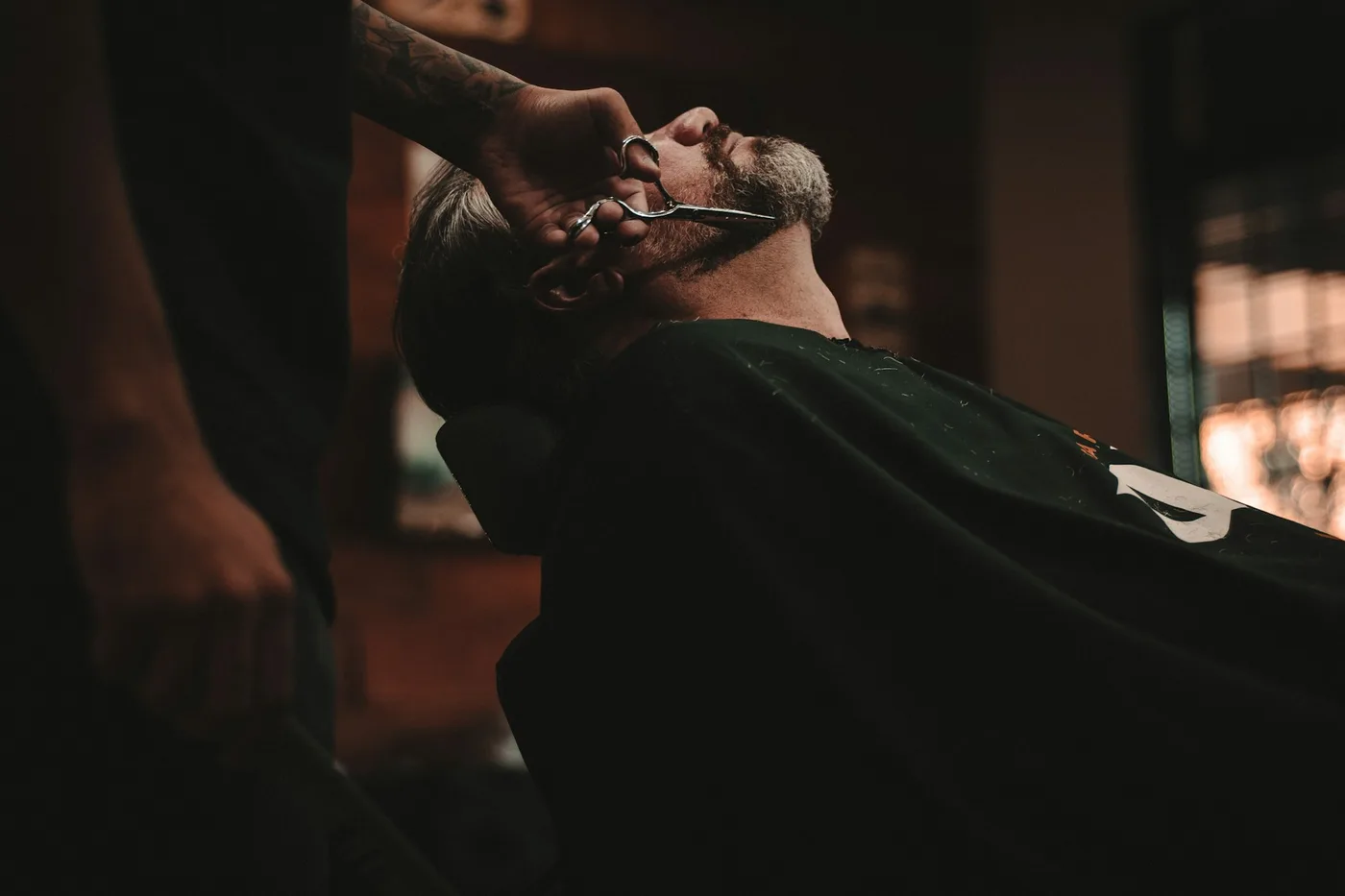 Profissional finalizando um corte de cabelo em fotografia de banco.